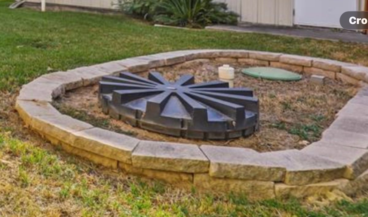 Aerobic septic system with decorative stone border cover — professional maintenance by Harris County Septic, powered by Enviro-Pal, Inc.