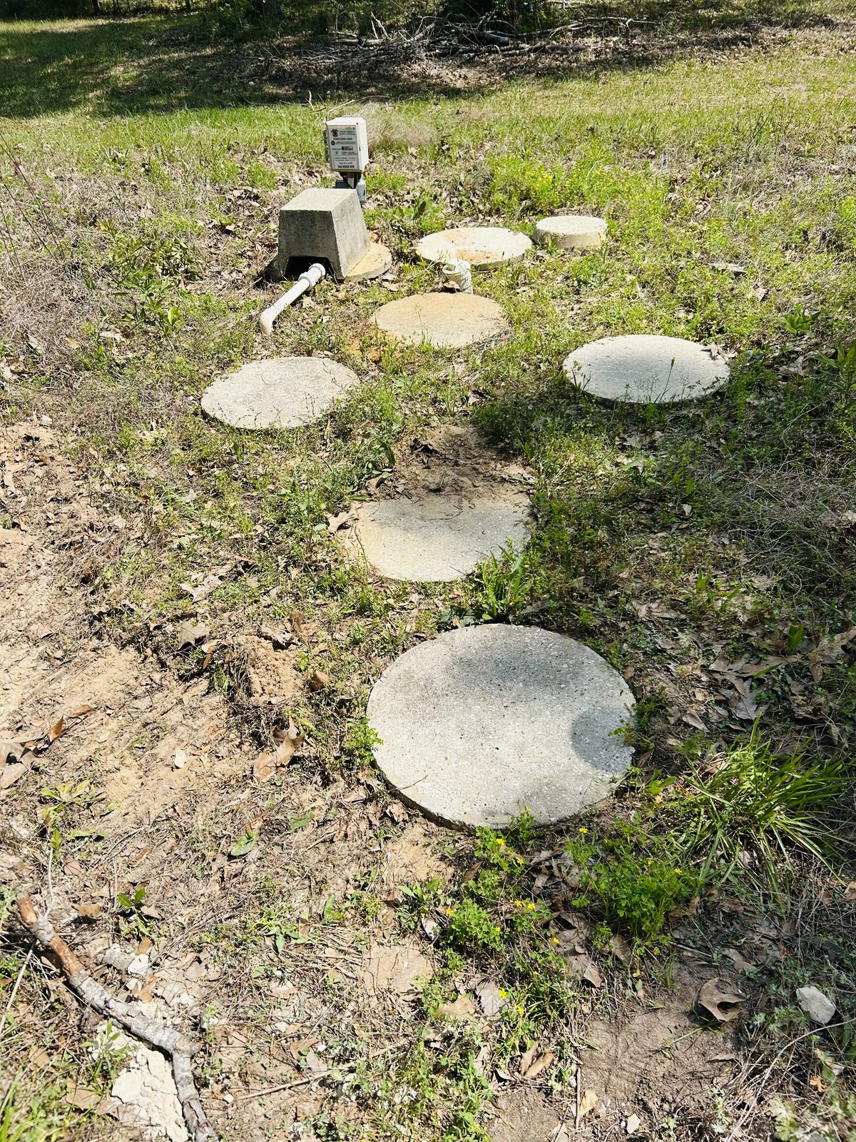 Jet aerobic system concrete access lids with control panel in residential yard